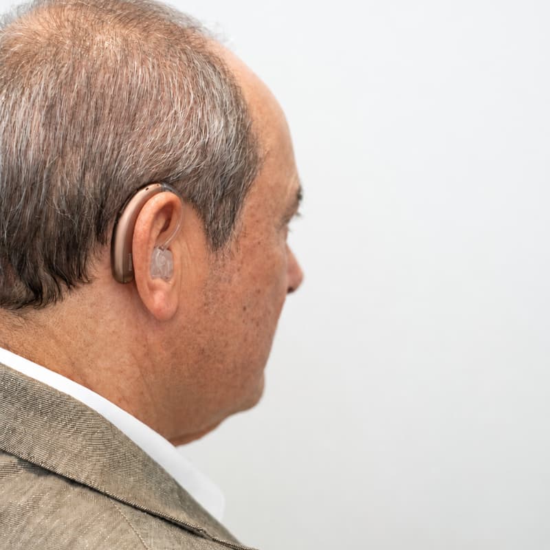 Man wearing Phonak Sky Lumity Behind-the-Ear (BTE) hearing aid